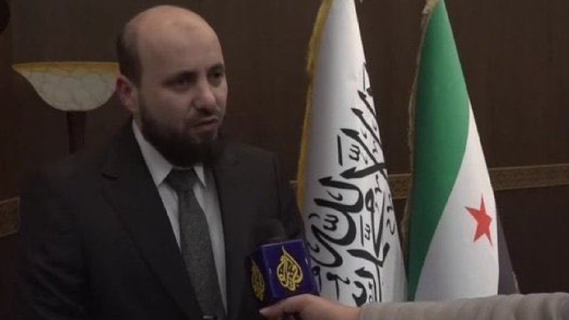 الادعاء بأن رئيس الوزراء السوري محمد البشير أعاد الراية الدينية إلى جانب العلم السوري بعد تنحيتها في الظهور الإعلامي مضلل